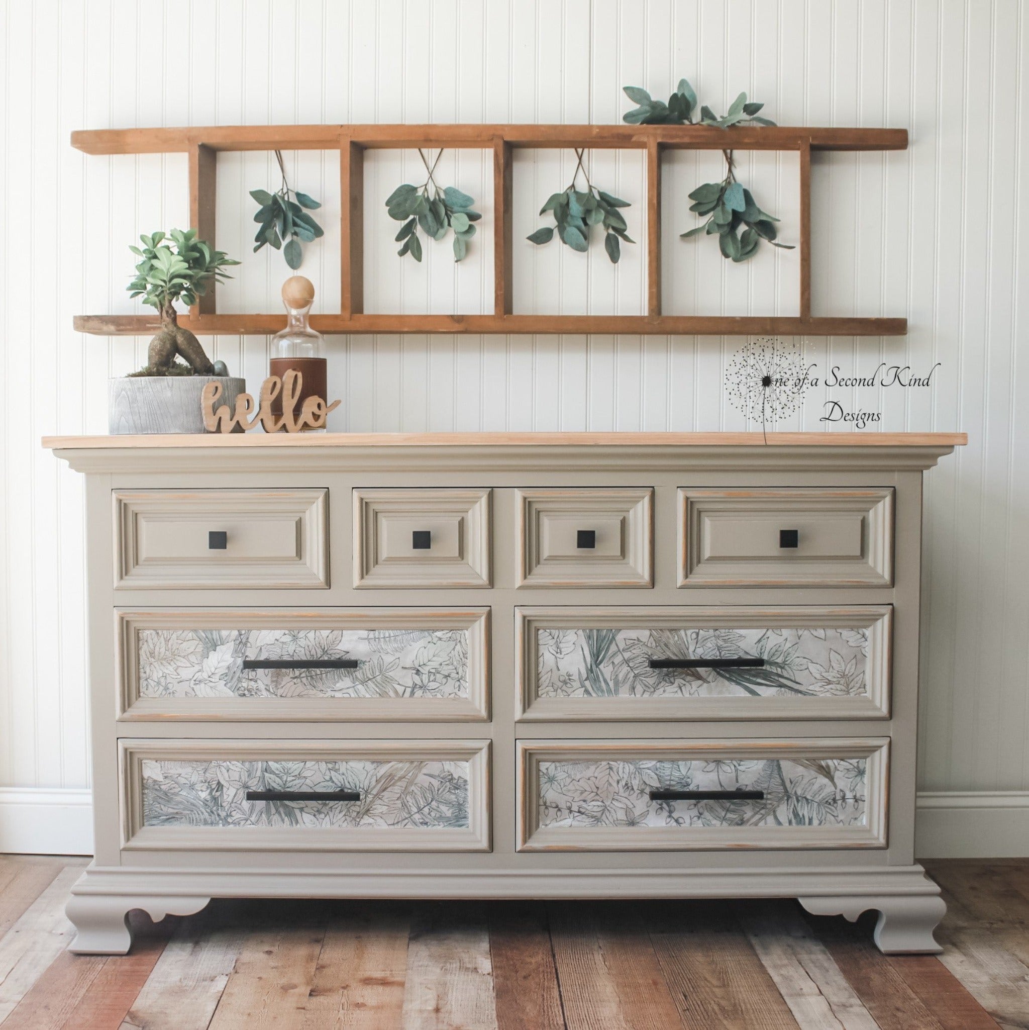 A vintage dresser refurbished by One of a Kind Designs is painted beige and features ReDesign with Prima's Tranquil Autumn tissue paper on its 4 bottom drawers.