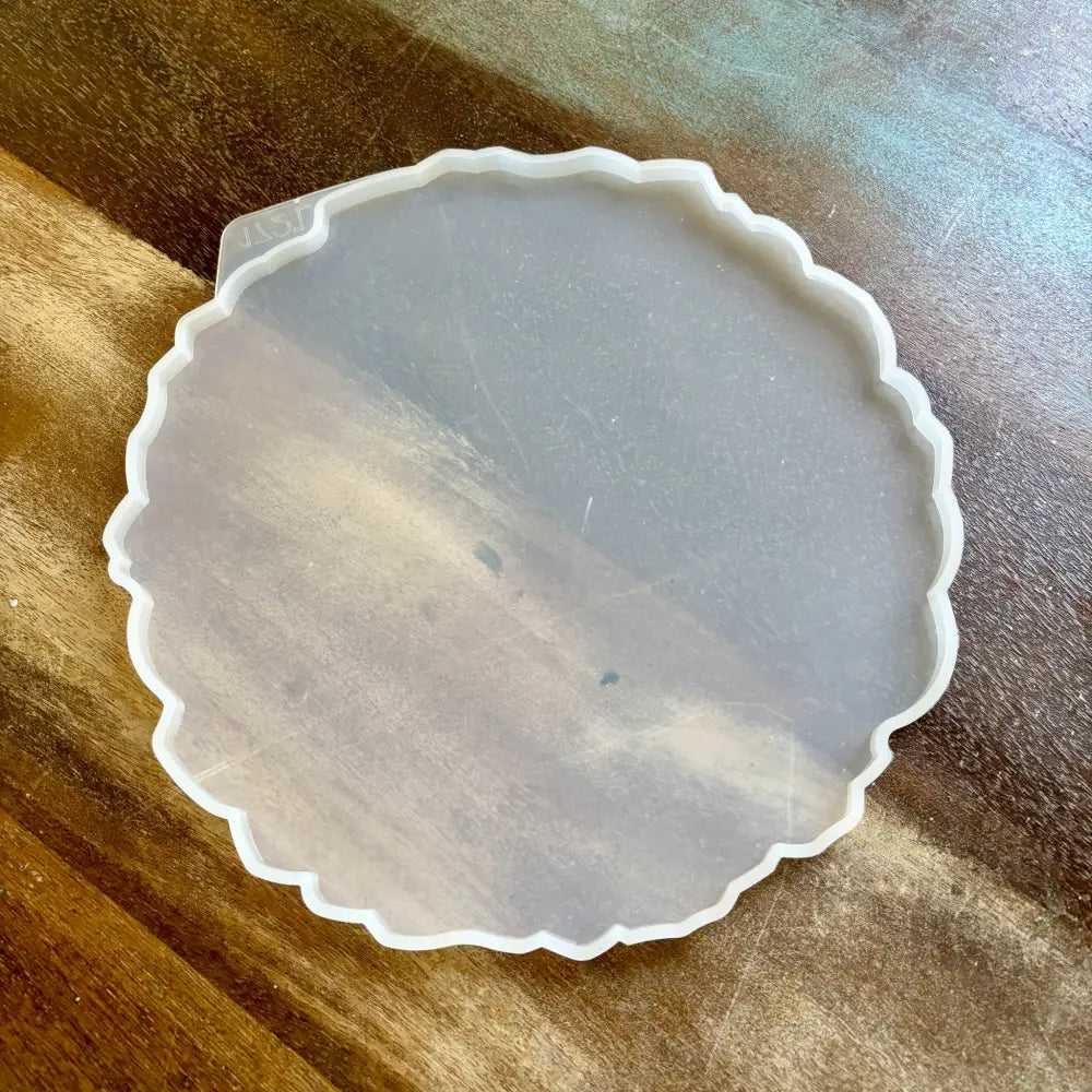 A silicone mold to make a 10.62" resin tray is against a wood background.