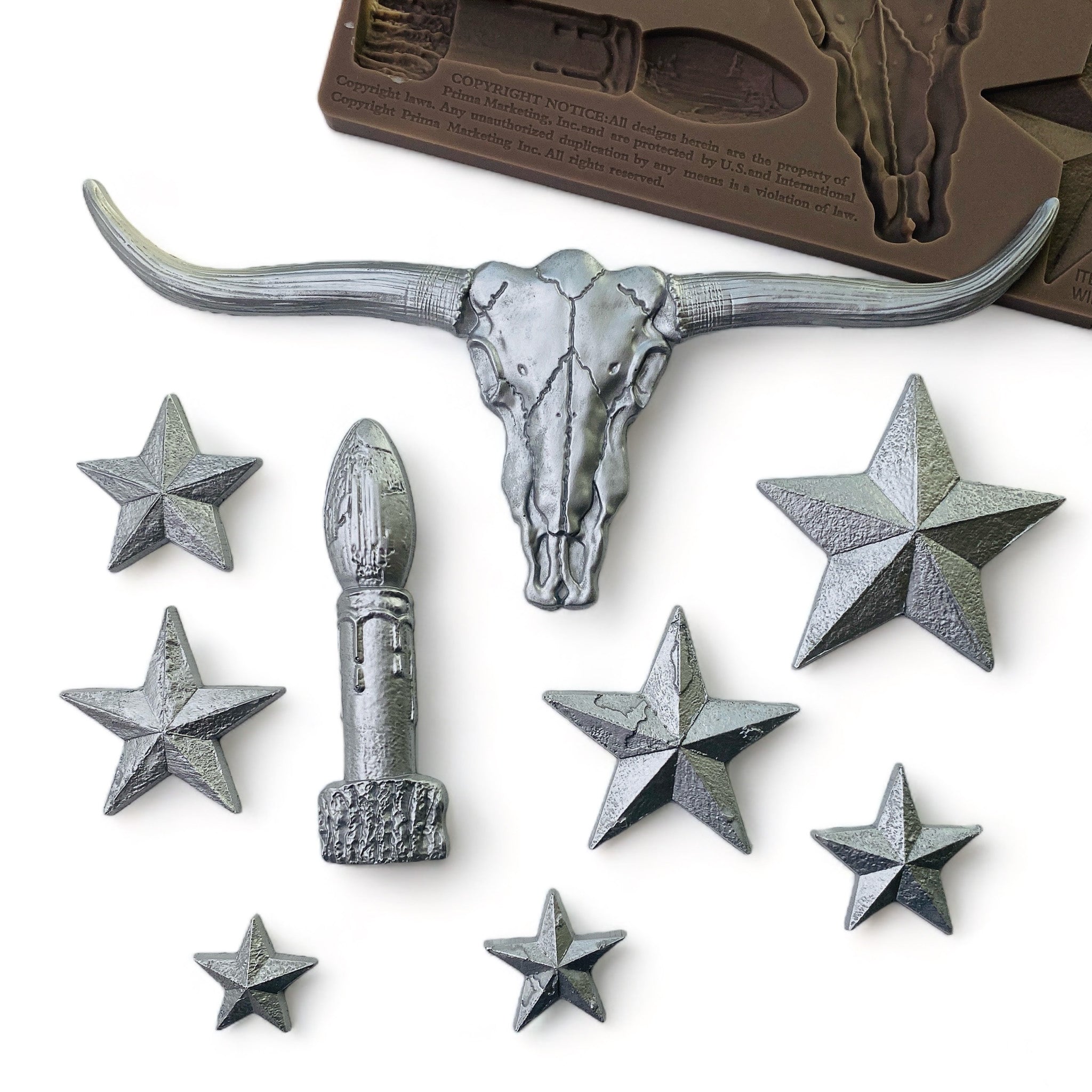 Silver colored silicone mold castings of a candle stick, longhorn bull skull, and 7 varying sizes of Texas style stars are against a white background.