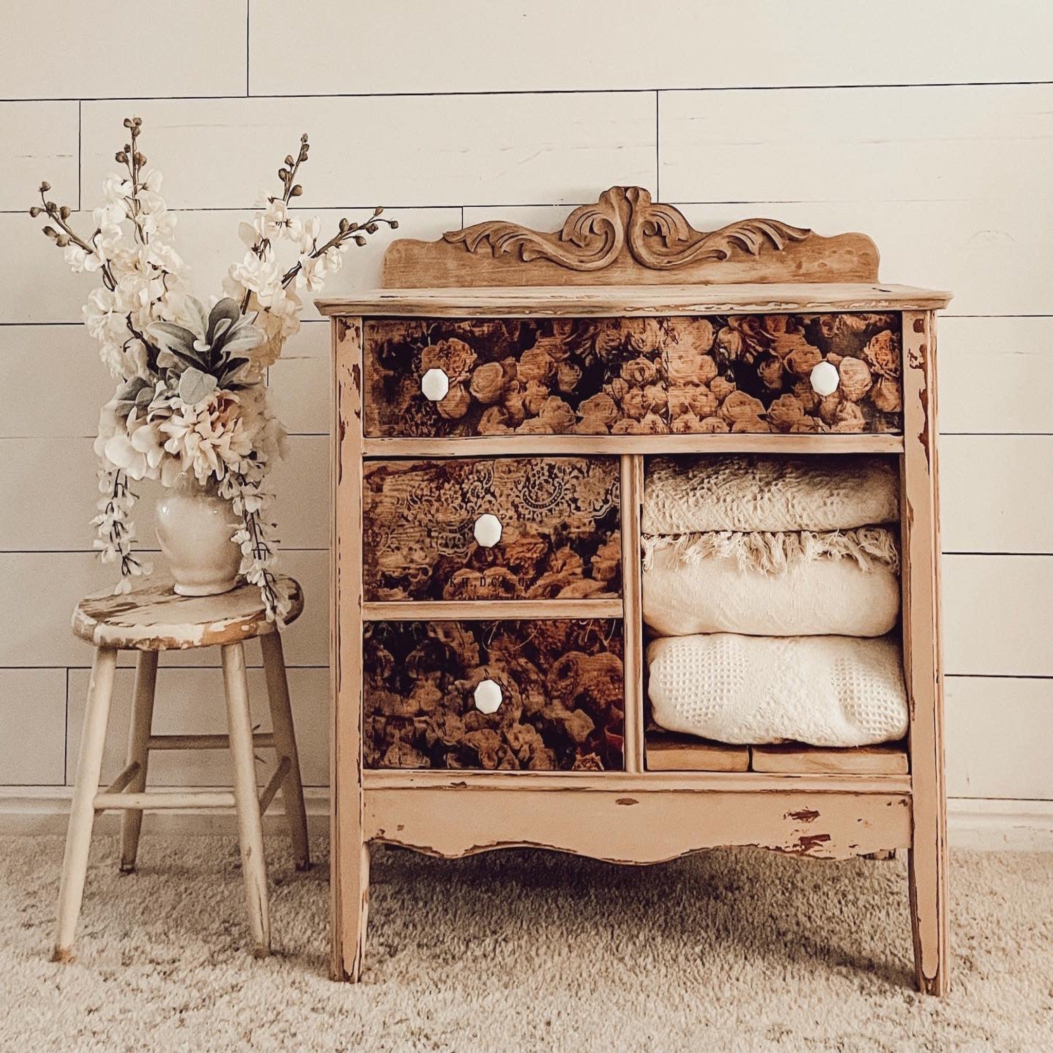 A vintage small dresser features ReDesign with Prima's Beautiful Dream tissue paper on its 3 drawers. The photo has a sepia color tone to it.