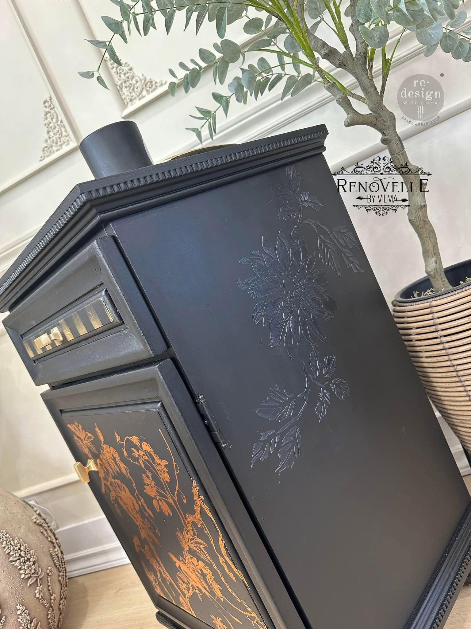 A side angle view of a vintage nightstand with a drawer and cabinet storage is painted black and features Pentart's Modeling Paste used with a floral stencil on the side.