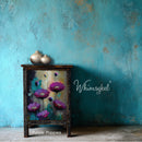 Purple poppies design on a side table against a blue wall.