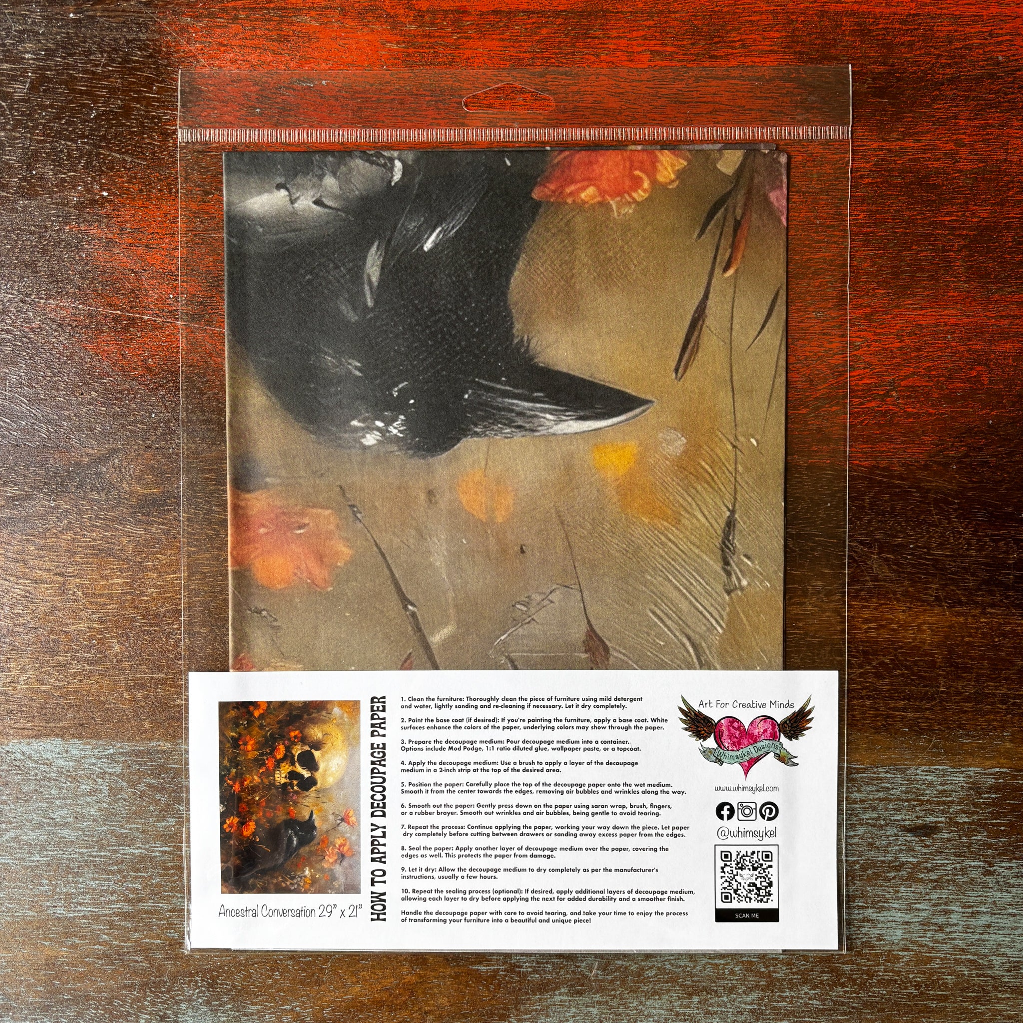 A package of Whimsykel's Ancestral Conversations tissue paper is against a dark wood background.