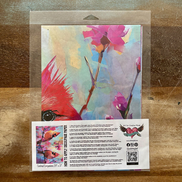 A package of Whimsykel's Cardinal Companions tissue paper is against a wood background.