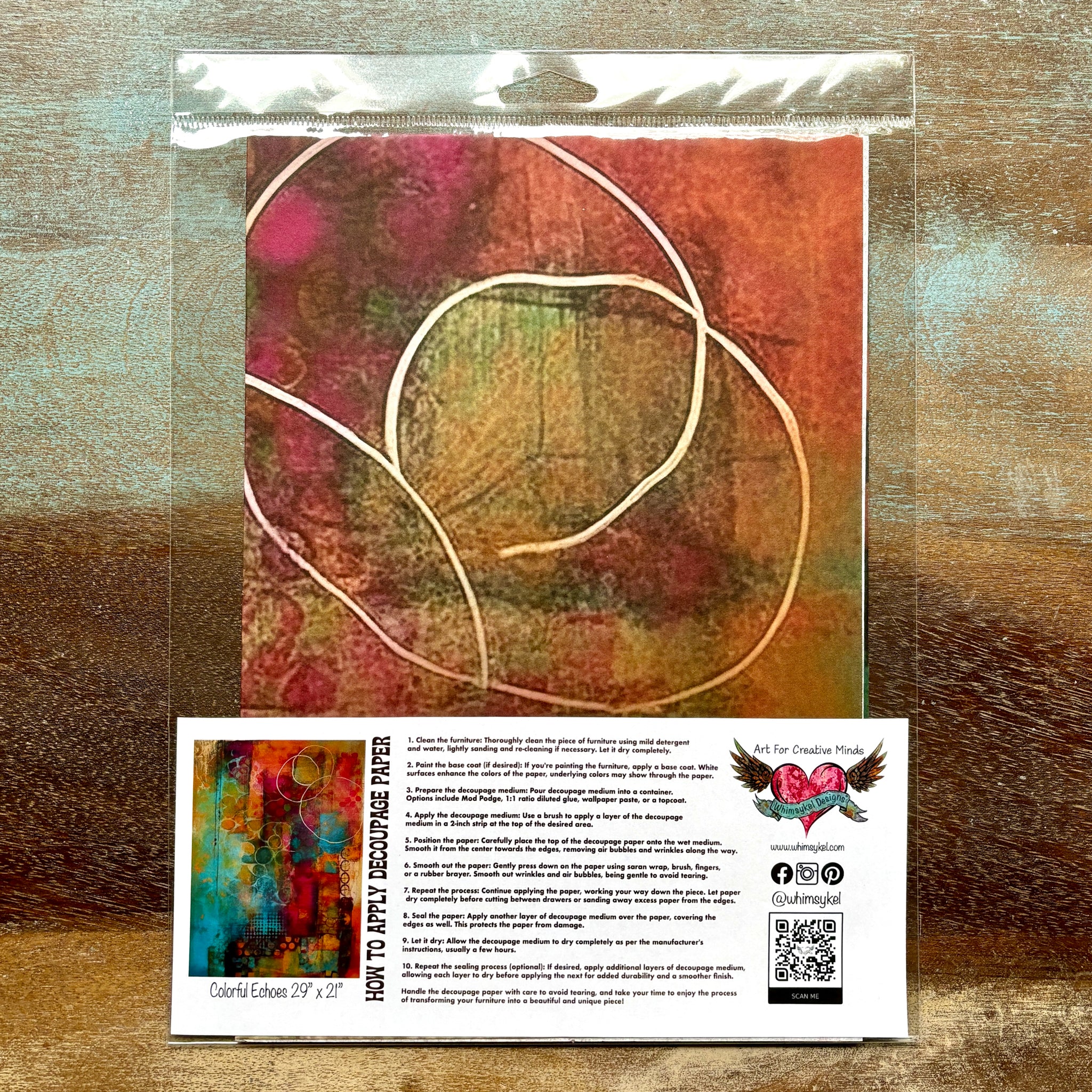 A package of Whimsykel's Colorful Echoes tissue paper is against a wood background.