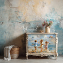 Decorative dresser with painted design of children by the sea against a textured wall.