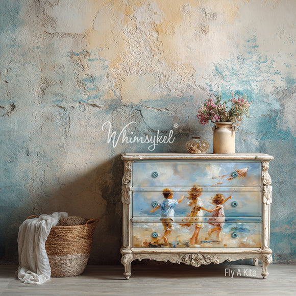 Decorative dresser with painted design of children by the sea against a textured wall.