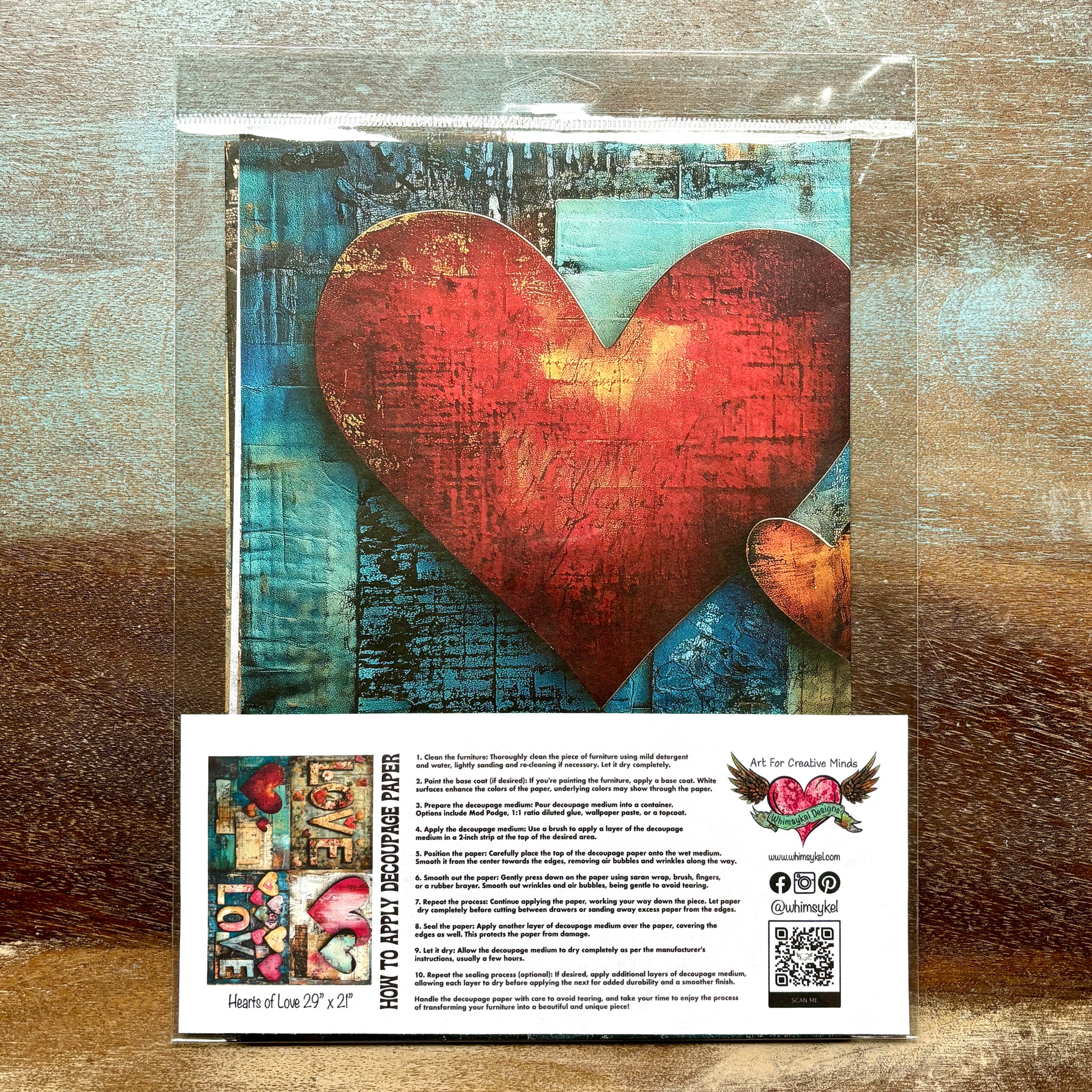 A package of Whimsykel's Hearts of Love tissue paper is against a wood background.