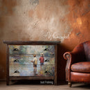 Wooden dresser with 'Just Fishing' design next to a leather chair against a textured wall, with 'Whimsykel' branding.