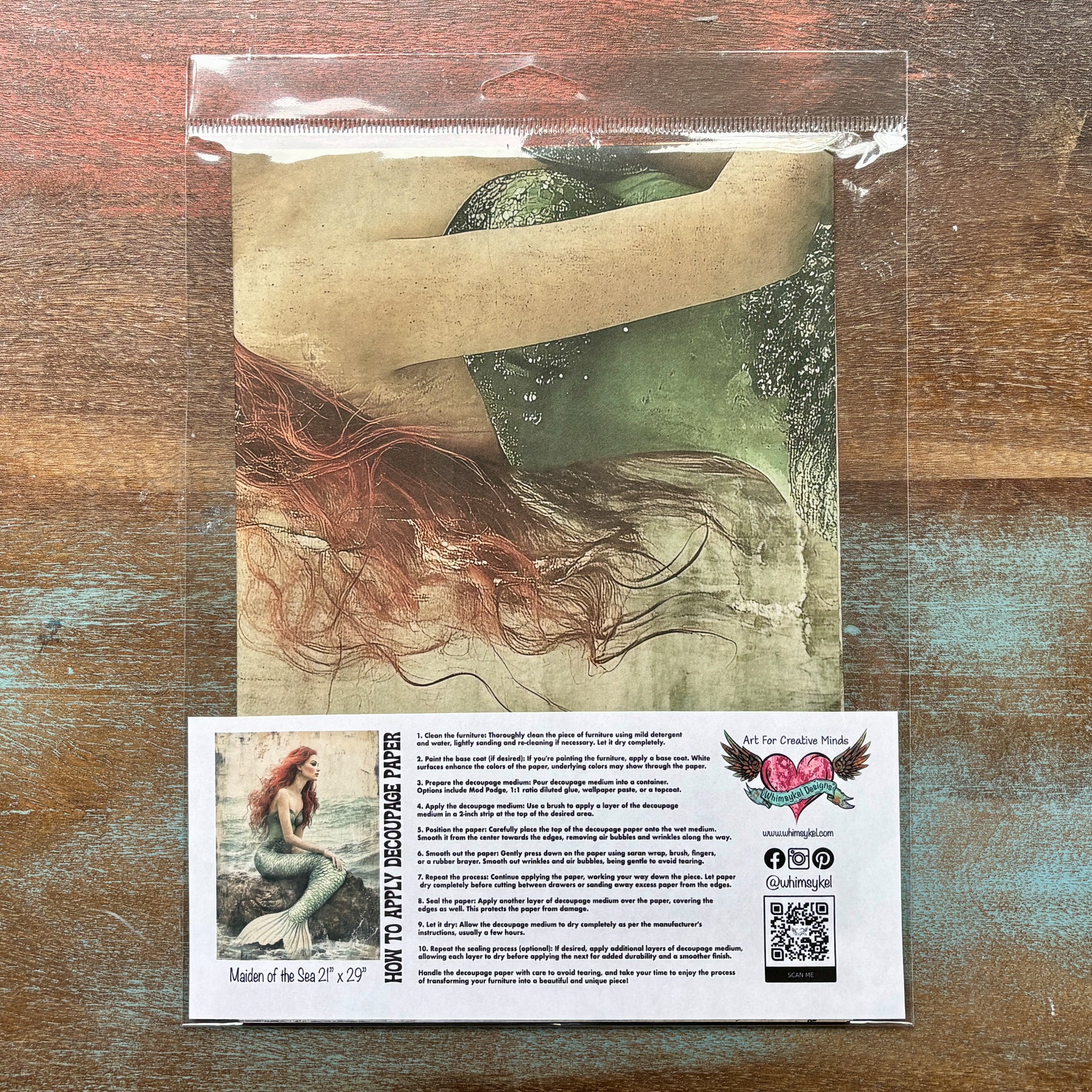 A package of Whimsykel's Maiden of the Sea tissue paper is against a wood background.