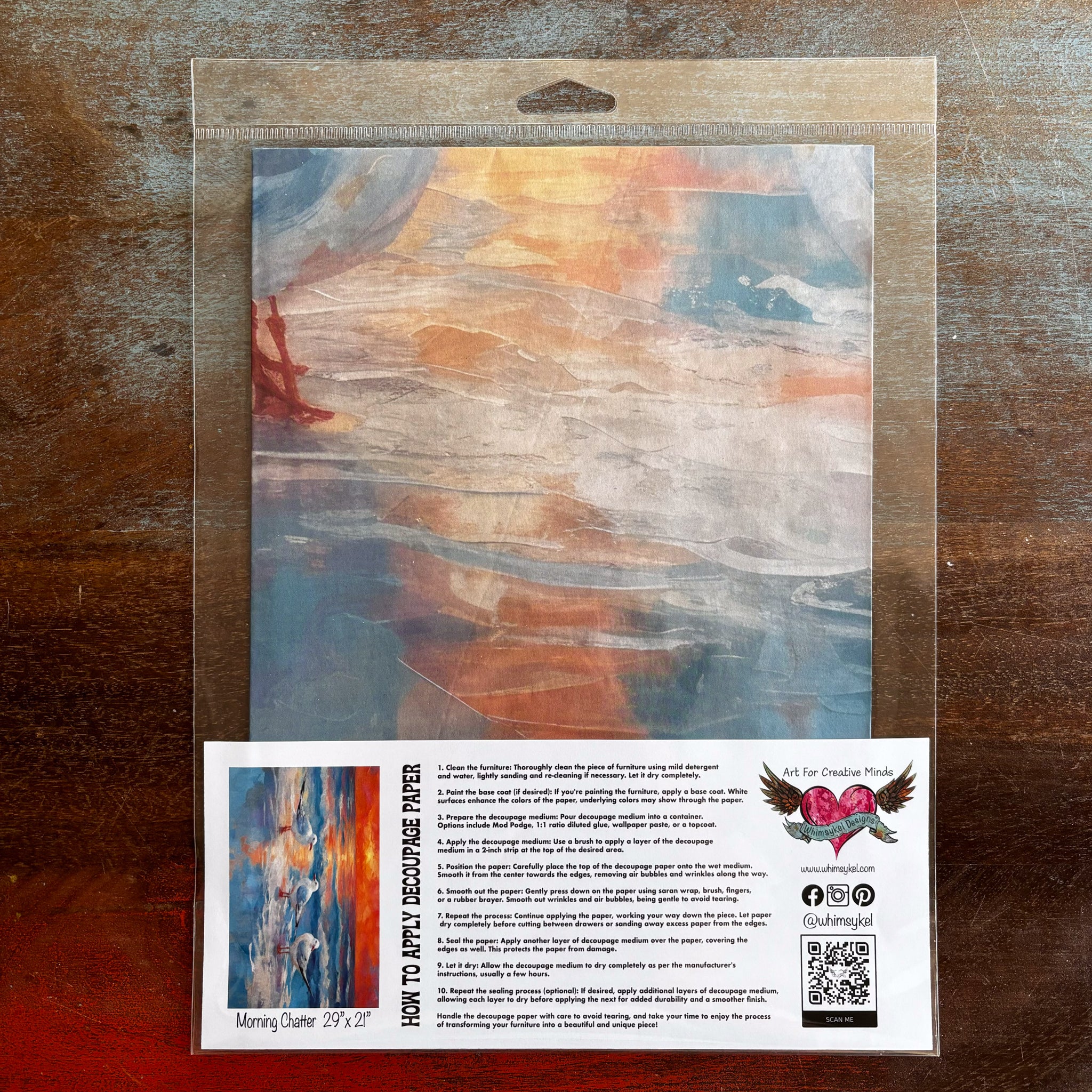 A package of Whimsykel's Morning Chatter tissue paper is against a dark wood background.