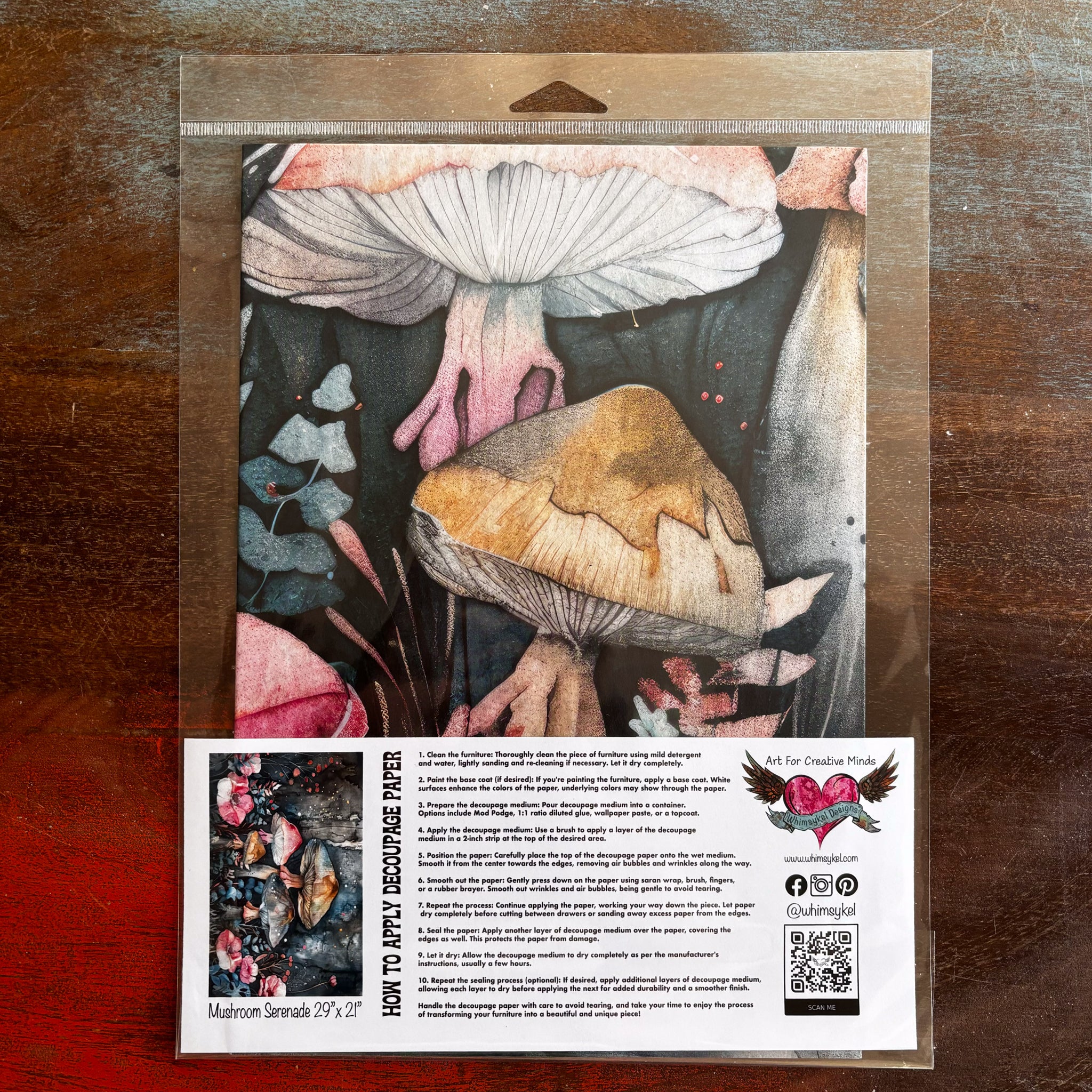 A package of Whimsykel's Mushroom Serenade tissue paper is against a dark wood background.