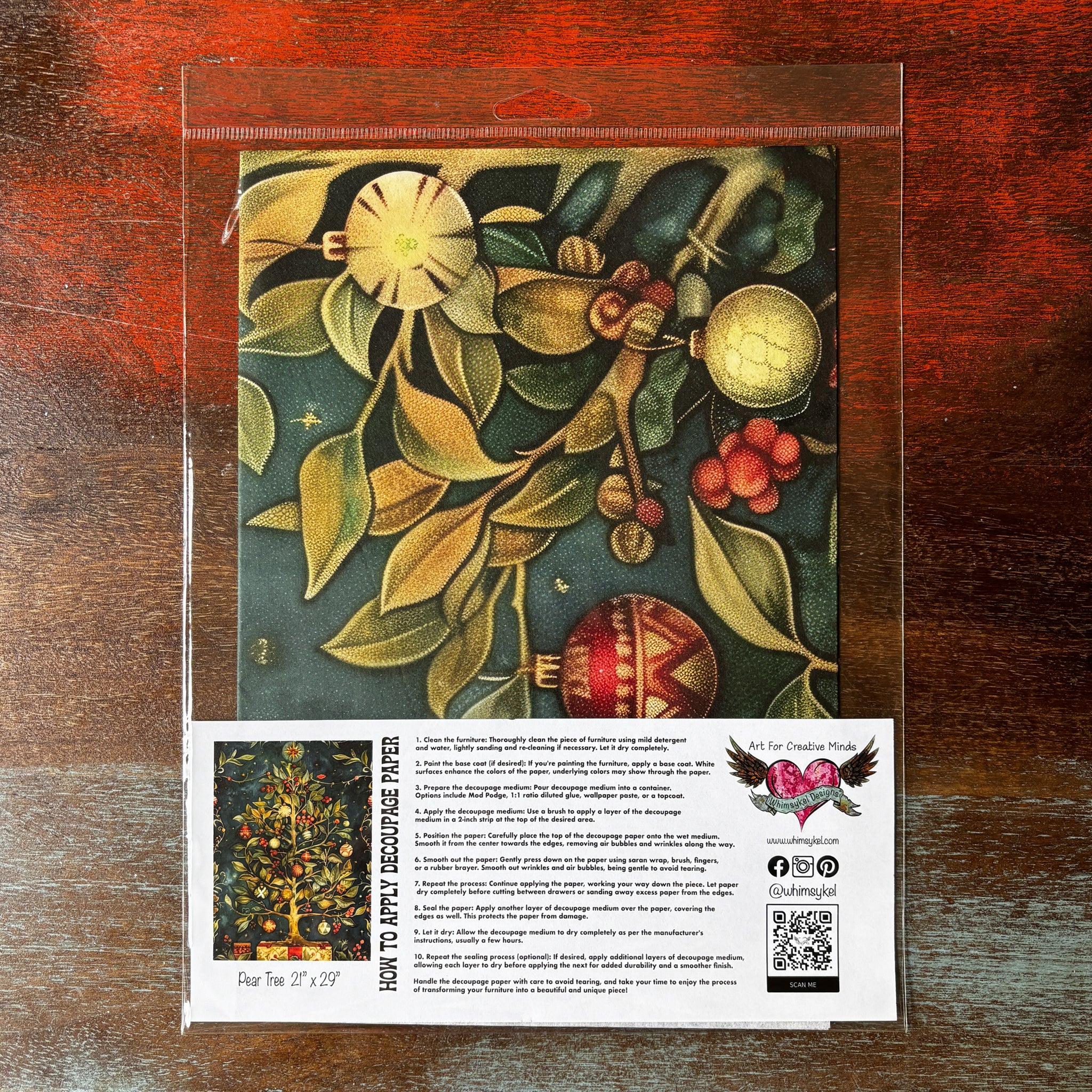 A package of Whimsykel's Pear Tree tissue paper is against a dark wood background.