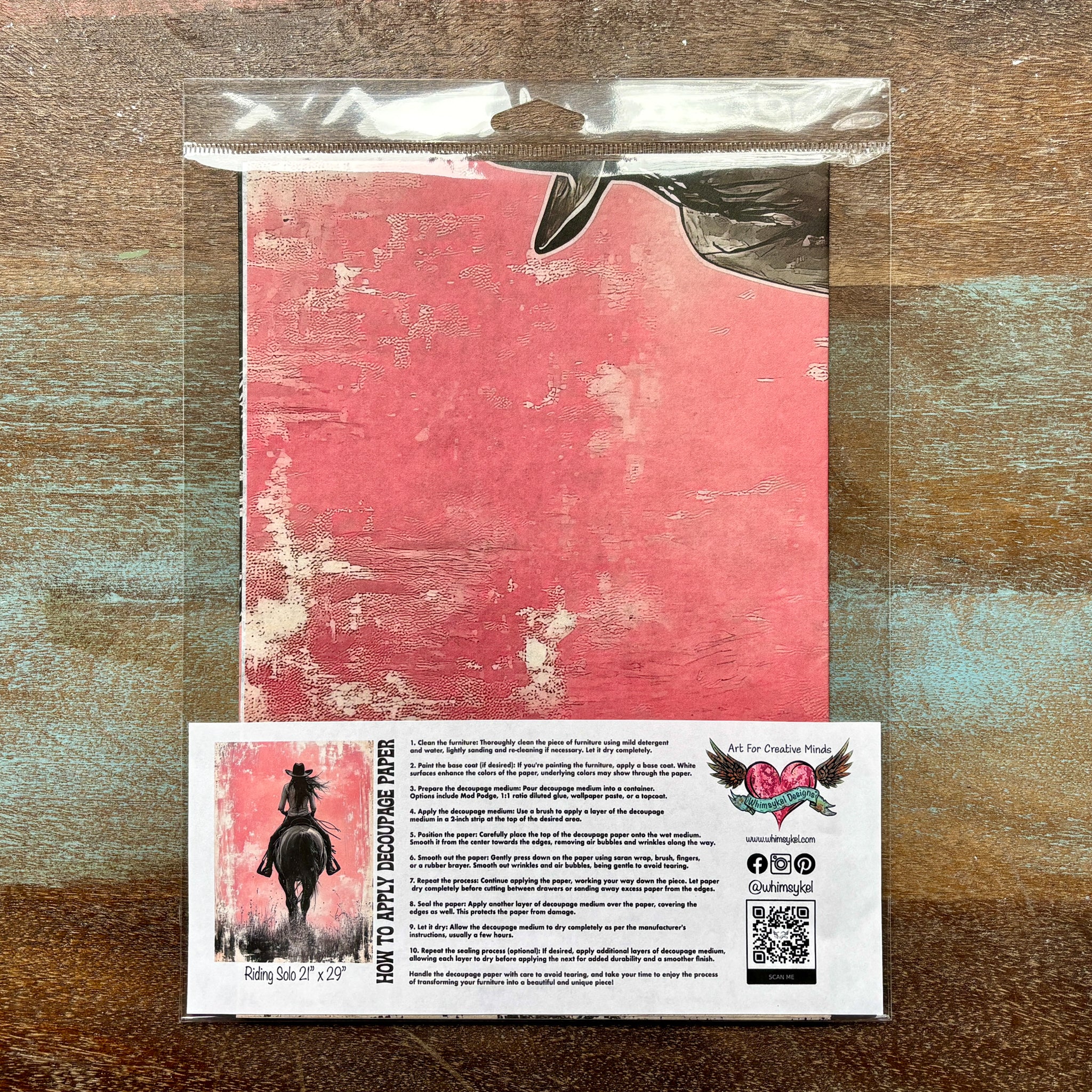 A package of Whimsykel's Riding Solo tissue paper is against a wood background.