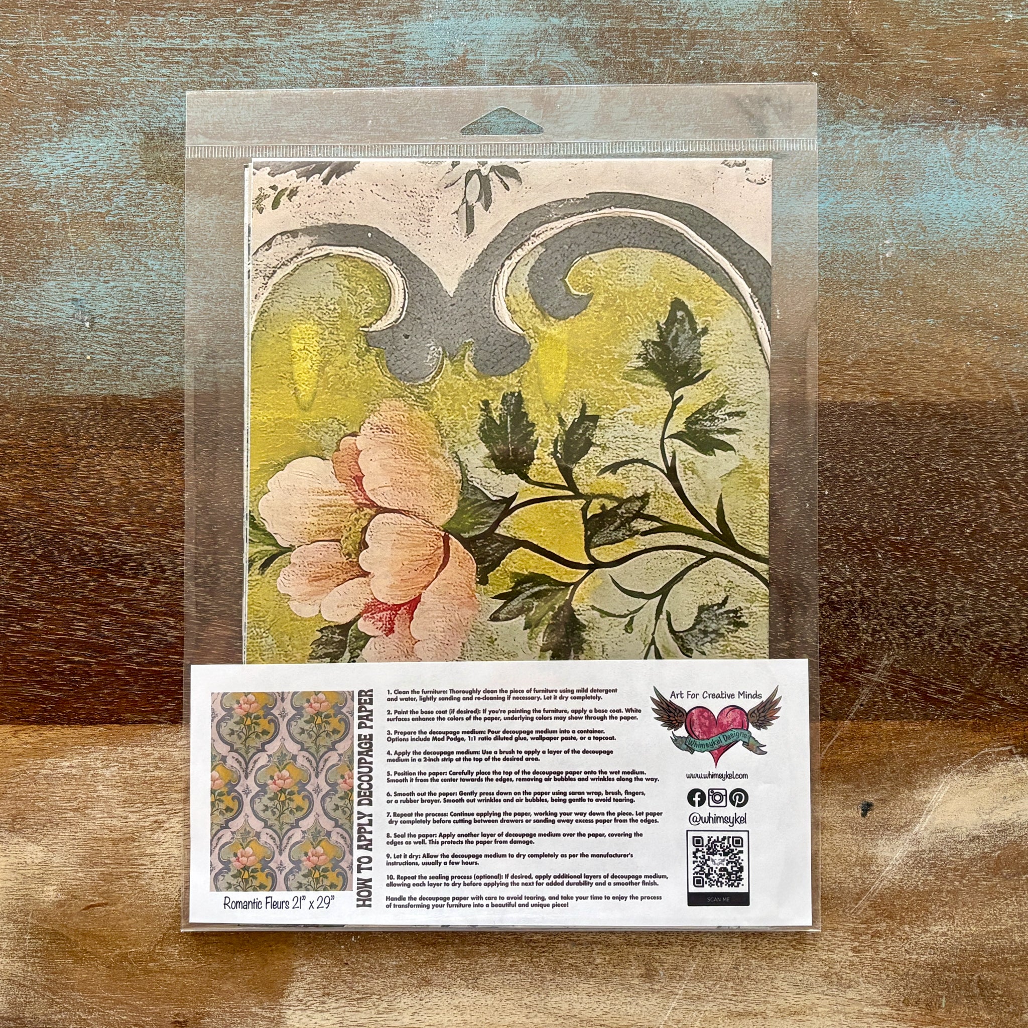A package of Whimsykel's Romantic Fleurs tissue paper is against a wood background.
