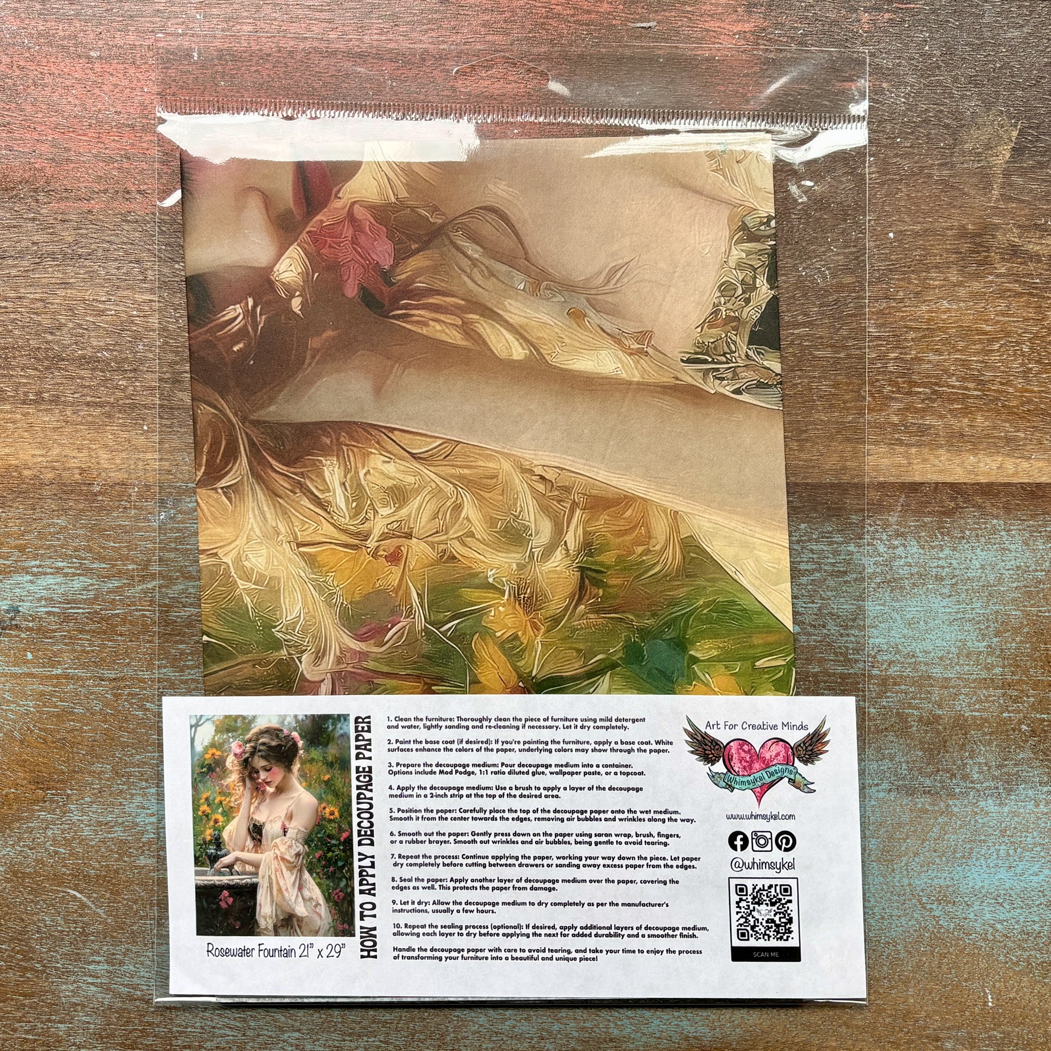 A package of Whimsykel's Rosewater Fountain tissue paper is against a wood background.