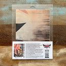 A package of Whimsykel's Shadow and Sol tissue paper is against a wood background.