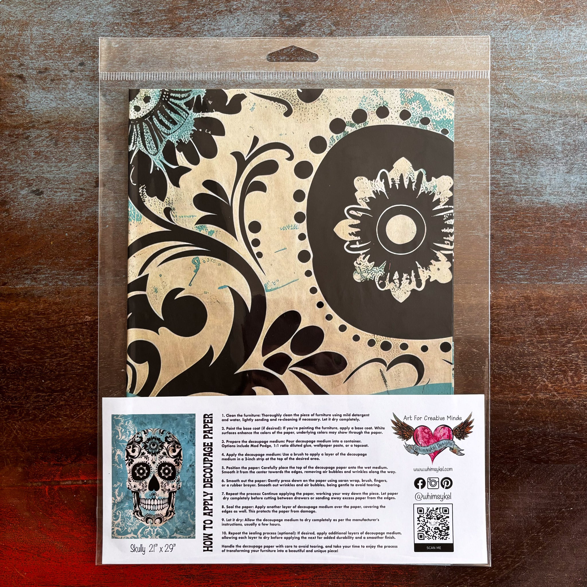 A package of Whimsykel's Skully tissue paper is against a dark wood background.