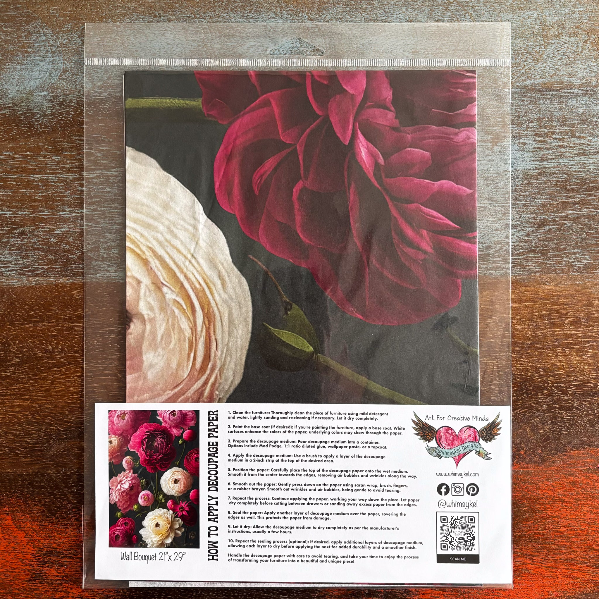 A package of Whimsykel's Wall Bouquet tissue paper is against a dark wood background.