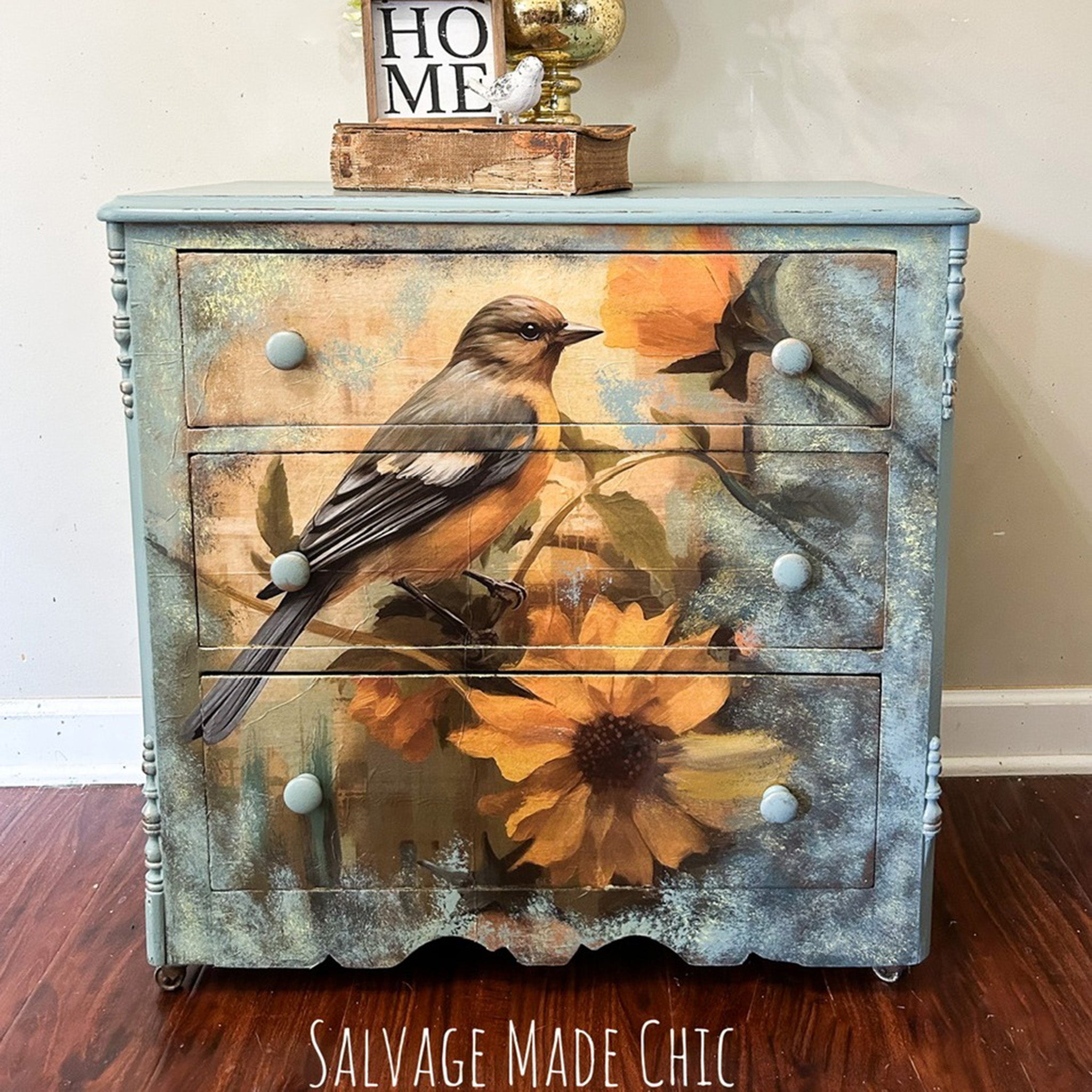 A small vintage 3-drawer dresser refurbished by Salvage Made Chic is painted pale blue and features Whimsykel's October Bluebird tissue paper on the front.