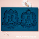 Blue Zuri A&B monogram silicone mold with decorative frames on pink background with orchid accents