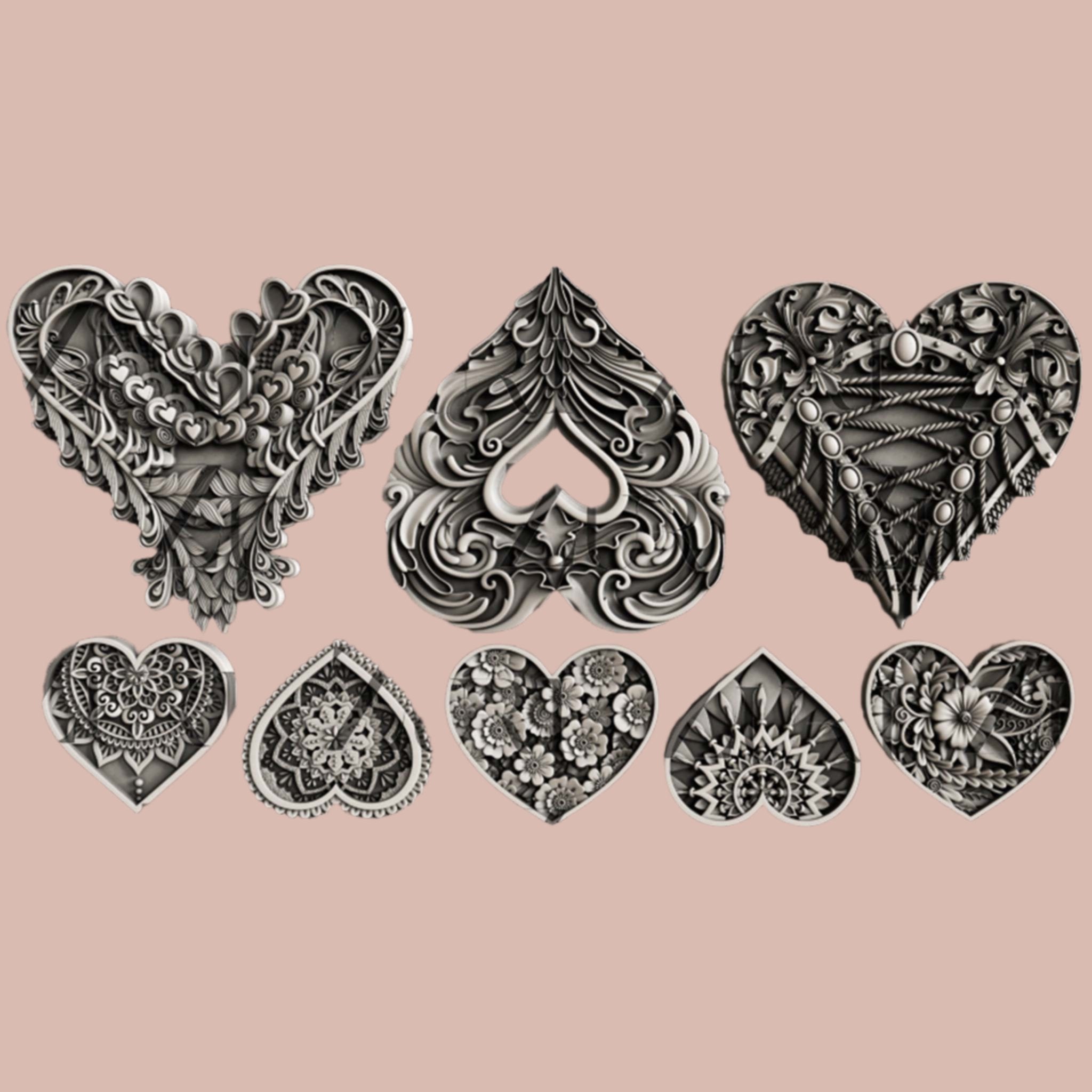 Silver colored silicone mold castings of 3 large and 5 small ornately decorated hearts are against a light pink background.