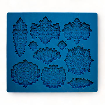 A blue silicone mold featuring 10 varying size Baroque style medallion accents is against a white background.