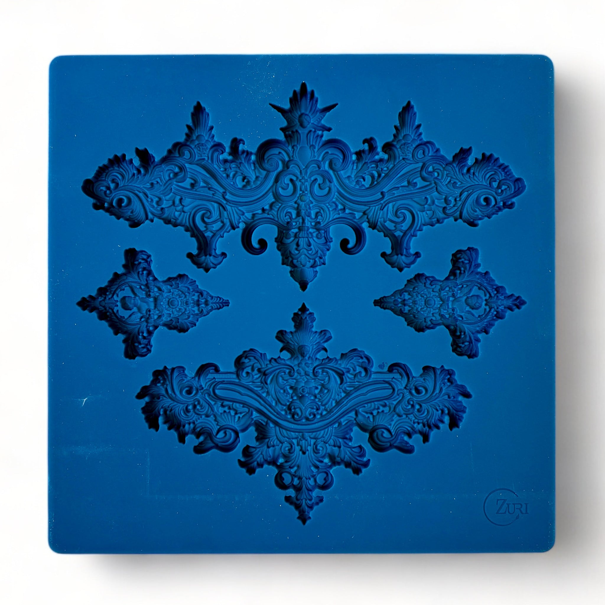 A blue silicone mold featuring 2 large, and 2 small ornate baroque accent center pieces is against a white background.