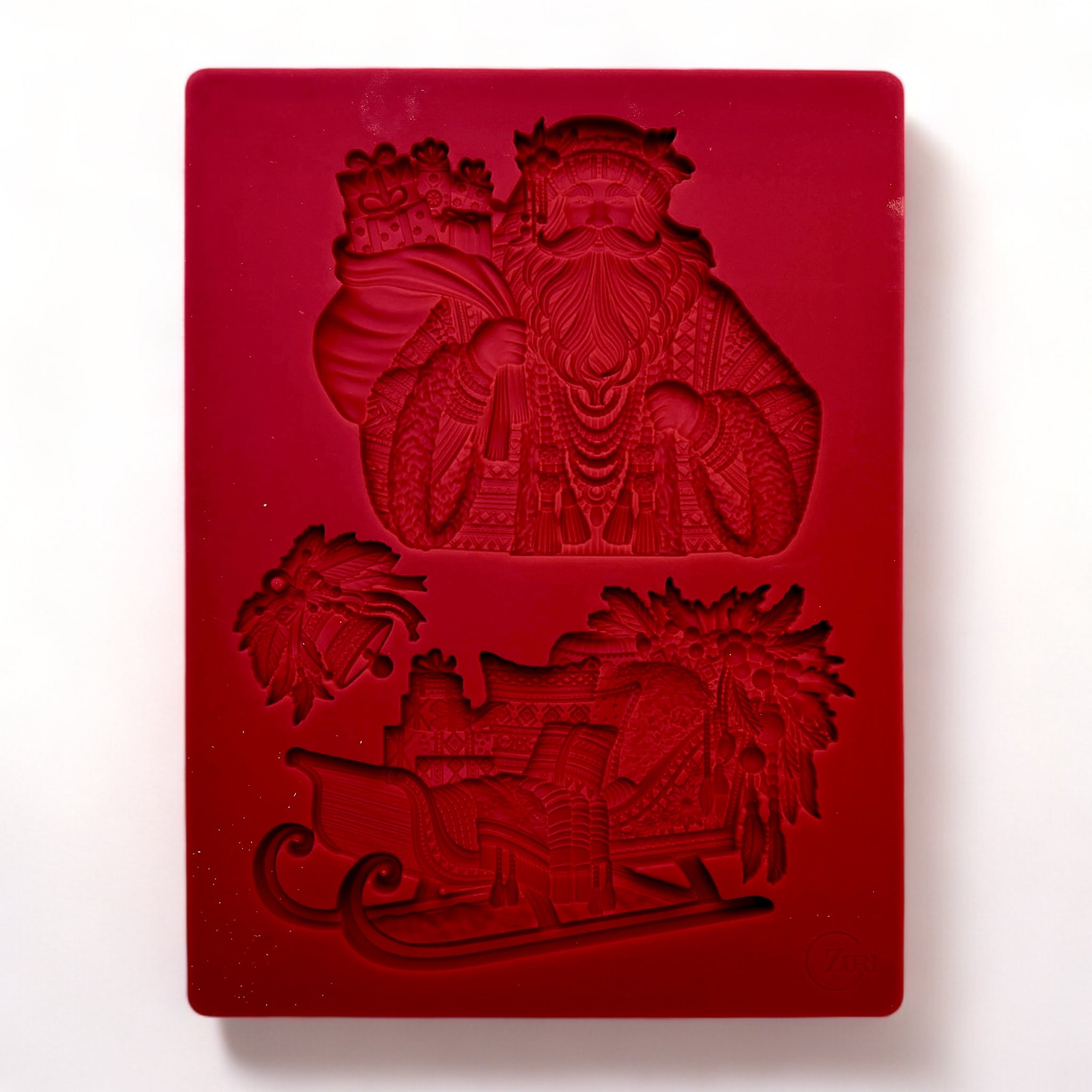 A red silicone mold of Zuri Design's Bohemian Santa and Sled is against a white background.