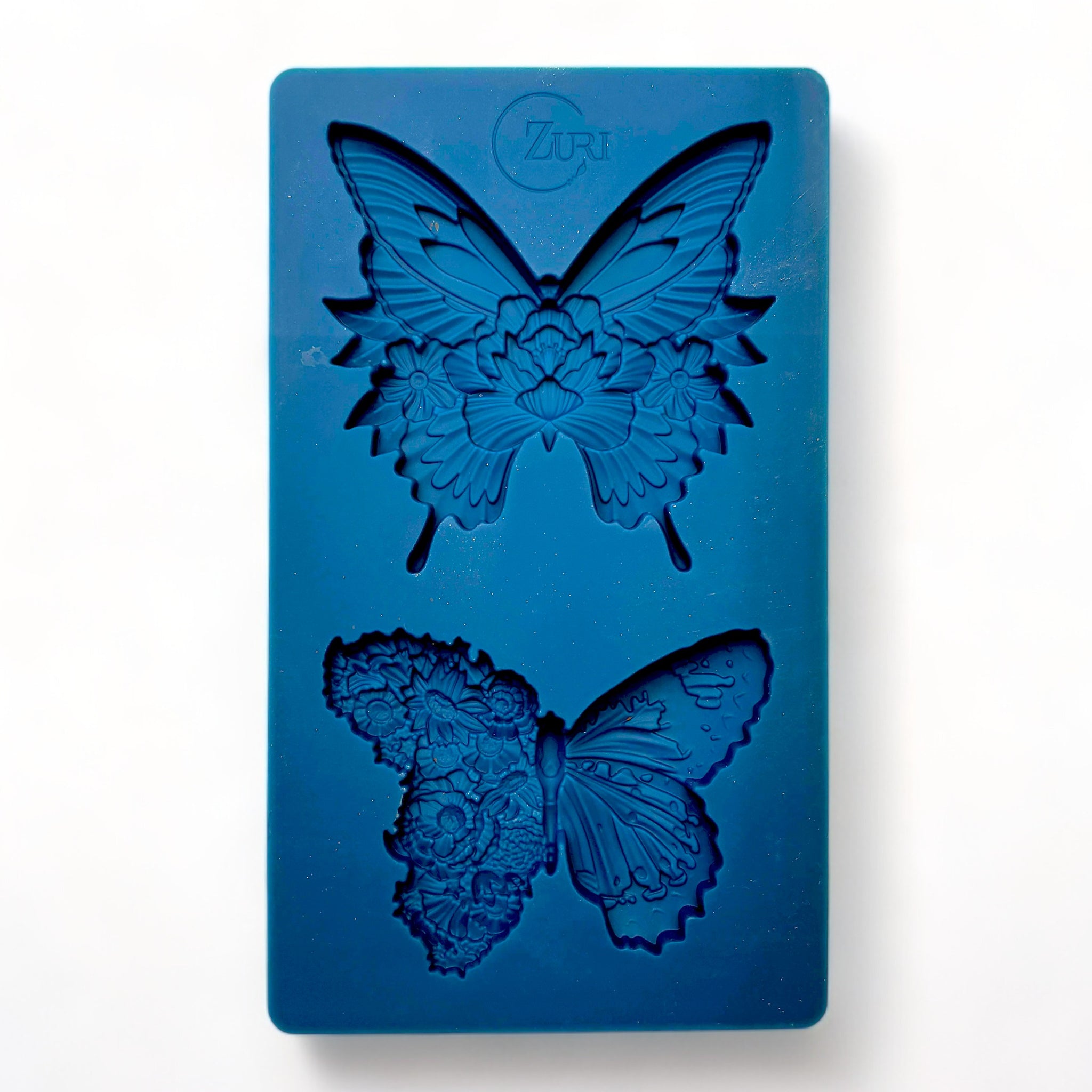 A blue silicone mold of Zuri Design's Butterfly Dance is against a white background.