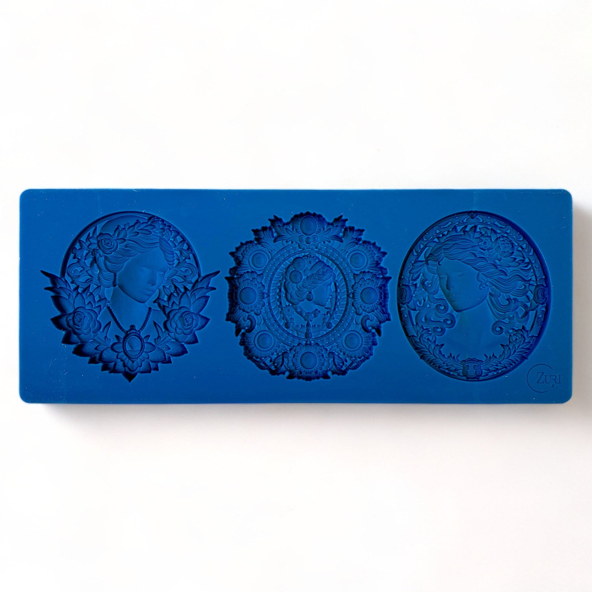 A blue silicone mold featuring 3 ornate cameo medallions is against a white background.