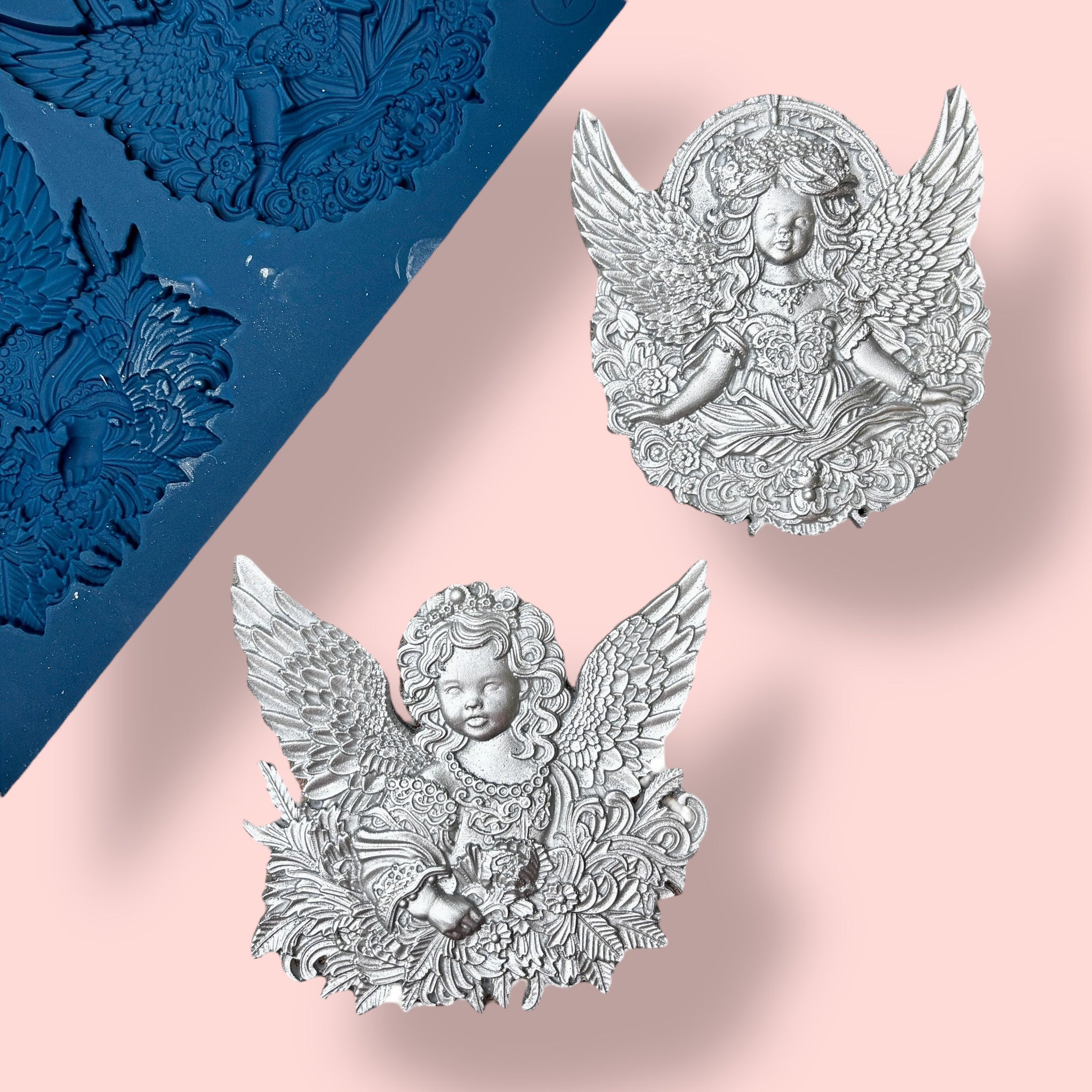 A blue silicone mold and silver colored castings of 2 ornately designed cherub angels are against a light pink background.