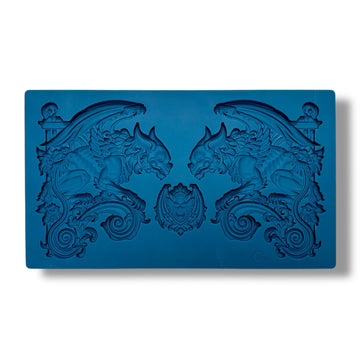 A blue silicone mold featuring 2 large gargoyle statues and a smaller gargoyle medallion is against a white background.