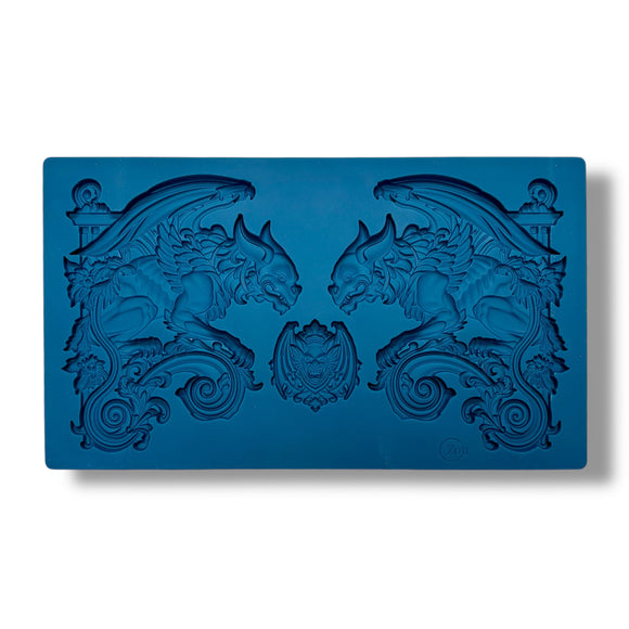A blue silicone mold featuring 2 large gargoyle statues and a smaller gargoyle medallion is against a white background.