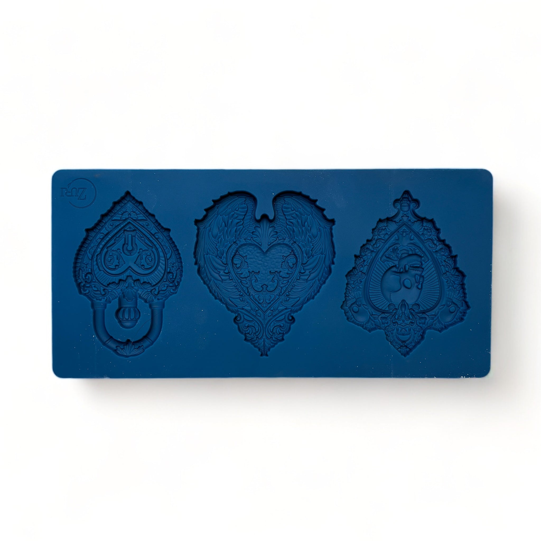 A blue silicone mold of 3 hearts with ornate designs like skulls, wings, and a lock is against a white background.