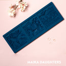 A blue silicone mold of 3 tiles featuring butterflies, flowers and calligraphy is against a light pink background.