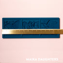 A blue silicone mold of 3 tiles featuring butterflies, a lace border, and script writing is against a light pink background. A gold ruler reading 13.4" length sits on the mold.