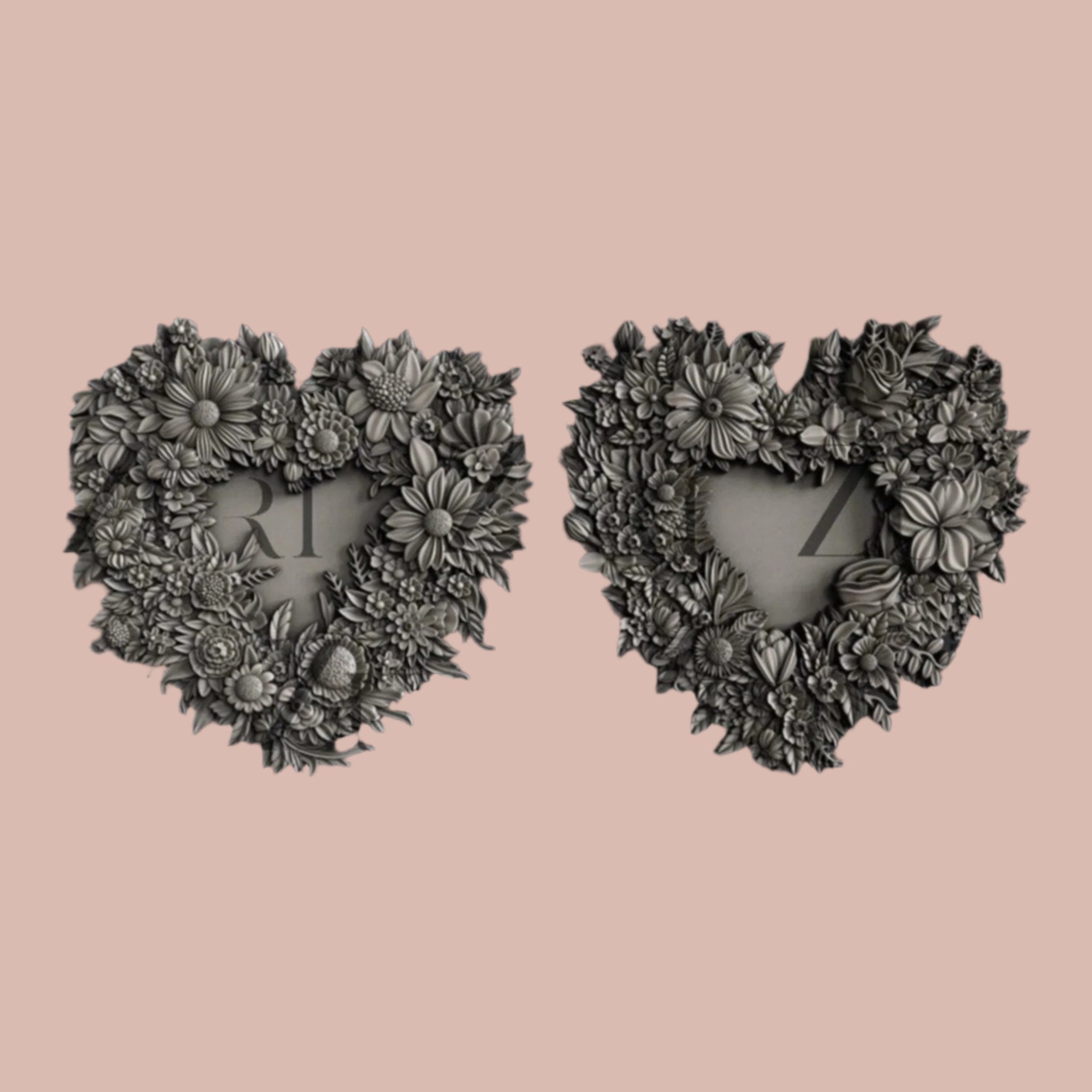 Silver colored silicone mold castings of 2 floral heart-shaped wreath frames are against a light pink background.