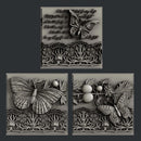 Silver colored castings of 3 tiles featuring butterflies, a lace border, and script writing are against a dark grey background.