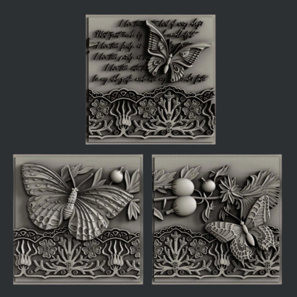 Silver colored castings of 3 tiles featuring butterflies, a lace border, and script writing are against a dark grey background.