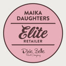 A white background with a pink circle with a brown outline and brown text reading: Maika Daughters. Elite retailer. Dixie Belle paint company.