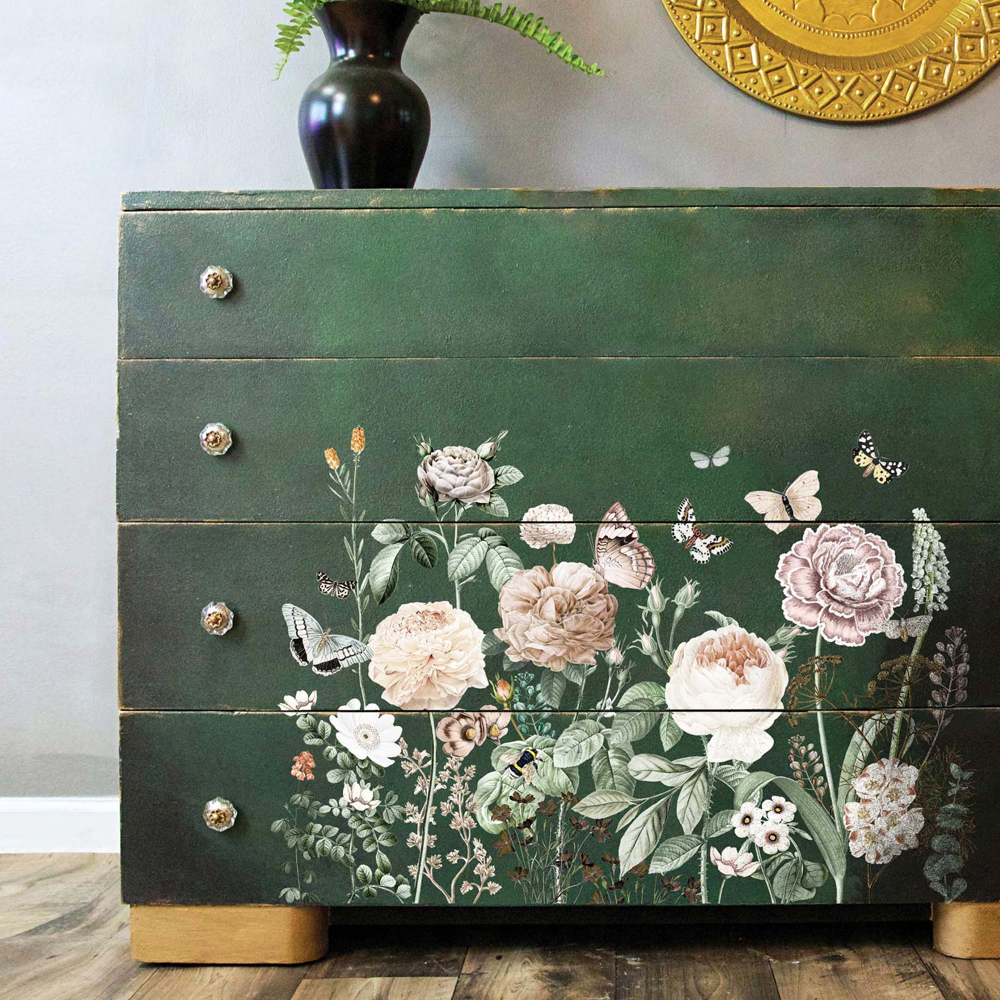 A close-up of a vintage dresser is painted hunter green and features the All the Flowers transfer on its drawers.