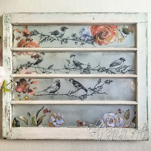 A wooden frame with the birds and berries and ruby rose transfer in the center. A white Eclat designs by Crystin furniture made divine logo on the bottom right corner.