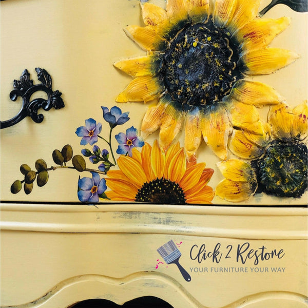 Close up of a yellow furniture piece with the Sunflower Fields transfer on top. A black Click 2 Restore your furniture your way logo on the bottom right.