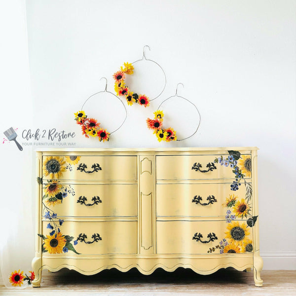 Yellow dresser with the Sunflower Fields transfer on top. A gray Click 2 Restore your furniture your way logo on the left.