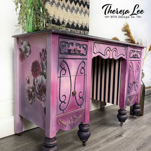A vintage desk refurbished by Theresa Lee NTS Design Company is painted a soft blend of pinks and purples and features the Buds and Branches transfer on its sides.