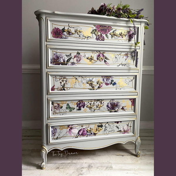 A French Provencial 5-drawer chest dresser refurbished by The Top Drawer is painted a soft white with gold accents and features Buds and Branches on its drawers.