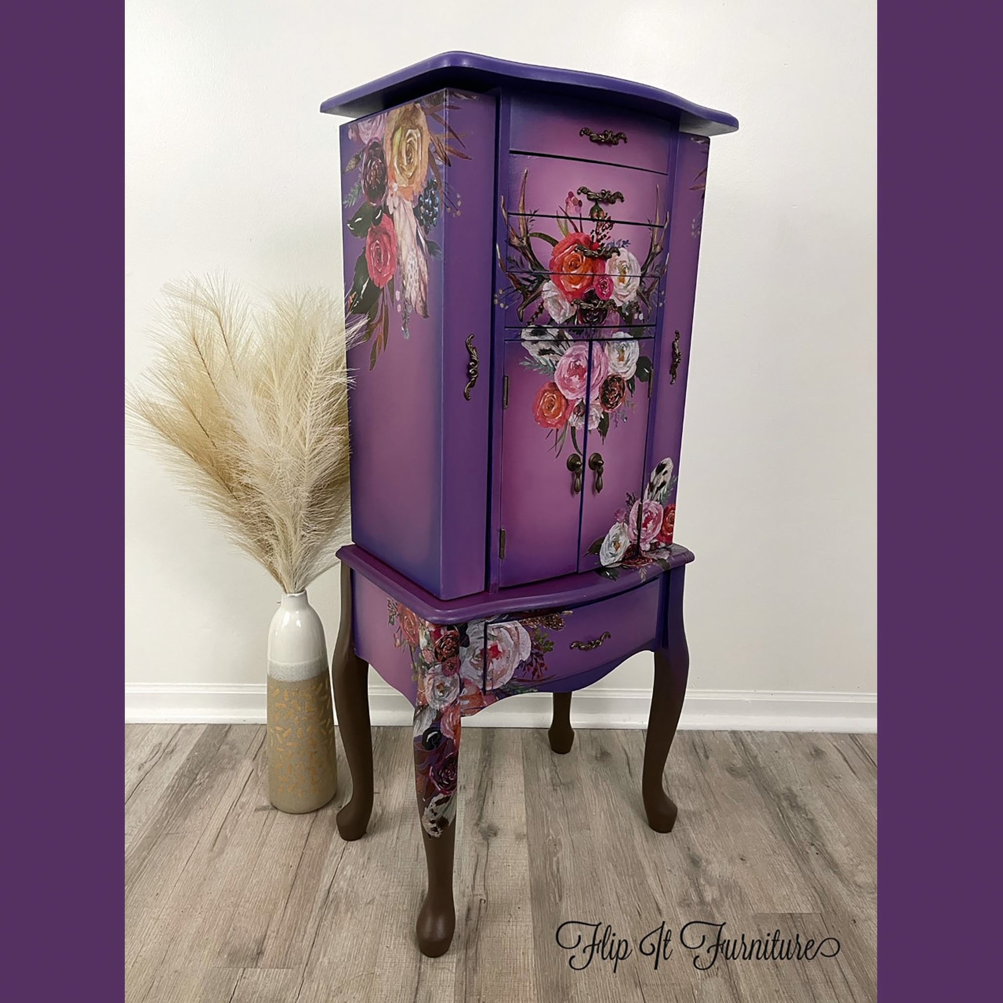 A vintage standing jewelry armoir refurbished by Flip It Furniture is painted in purple with pink center blending and features the Flower Child transfer.