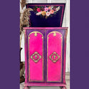 A vintage bar cabinet is painted in pink and purple and feautres the Flower Child transfer inside its lifting lid.