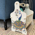 A vintage magazine rack refurbished by Tea and Forget-Me-Nots is painted a vanilla white and features the Retro Peacock transfer on it.